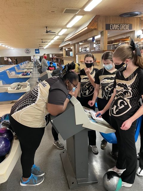 Members of the girls bowling team review the scores after a game against Central.