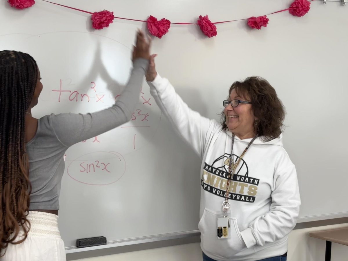 Ms. Prange as she succeeds in helping Pre-calculus student Imani Ongalo solve a problem. Ms. Prange makes sure to congratulate Imani in her success with a joyful high-five. She is anxiously awaiting the arrival of her retirement. Catch here at graduation.